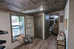 a bathroom with a toilet and a wooden ceiling at Enjoy Ozark History in Style! in Hasty