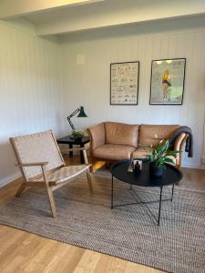 uma sala de estar com um sofá e uma mesa em Hus med sentral beliggenhet em Tysvær