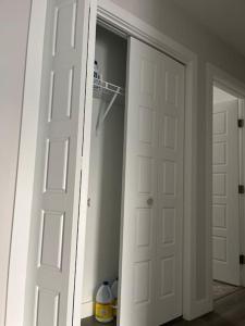 un armario con 2 puertas blancas y una habitación en Home for yourself, en Winnipeg