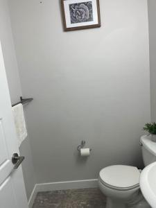La salle de bains blanche est pourvue de toilettes et d'un lavabo. dans l'établissement Home for yourself, à Winnipeg