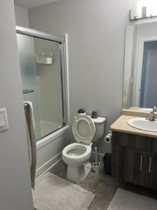 a bathroom with a toilet and a shower and a sink at Home for yourself in Winnipeg