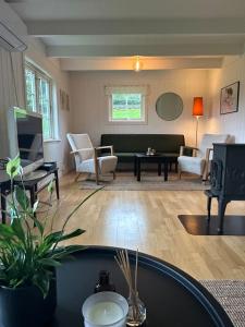 un soggiorno con divano e TV di Hus med sentral beliggenhet a Tysvær