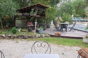 a patio with a table and chairs and a dog at La chambre émeraude in Fayence