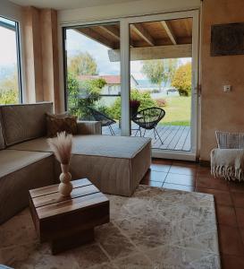 ein Wohnzimmer mit einem Sofa und einem Tisch in der Unterkunft Wunderschönes Haus direkt am See - Seeblick, großer Garten, Südbalkon, Carport & Smart-TV in Gaienhofen
