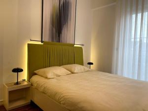 1 cama con cabecero verde en un dormitorio en Grandeur City Centre Apartment, en Pristina