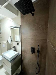 y baño con lavabo y espejo. en Grandeur City Centre Apartment, en Pristina