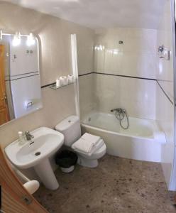 a bathroom with a sink and a toilet and a bath tub at Hostal Casa Martina in Guadalaviar