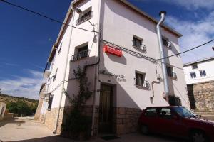 a red car parked in front of a building at Hostal Casa Martina in Guadalaviar