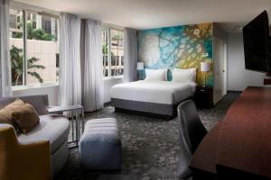 a hotel room with a bed and a couch at Courtyard Miami Dadeland in Miami +29 photos
