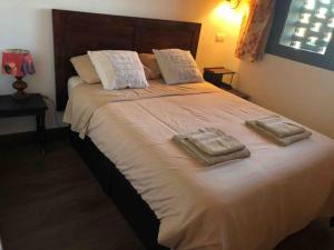 ein Schlafzimmer mit einem großen Bett mit zwei Handtüchern darauf in der Unterkunft CASA RURAL EN BOSQUE DE PALMERAS in Alberche del Caudillo
