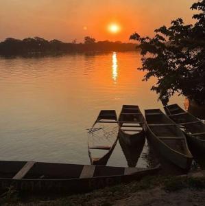 a group of boats sitting in the water at sunset at casa grande e confortável in Pirapora
