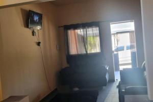 a living room with a couch and a television on the wall at casa grande e confortável in Pirapora