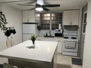 a kitchen with white appliances and a ceiling fan at Kasa Metrópolis in Carolina