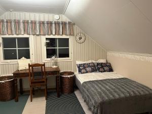 a bedroom with a bed and a desk and windows at Cozy house close to SantaVillage in Rovaniemi