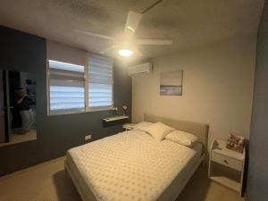 1 dormitorio con 1 cama y ventilador de techo en Kasa Metrópolis, en Carolina