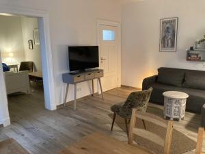 a living room with a couch and a flat screen tv at Hamburg City Homes in Hamburg