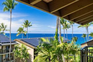 a view from the balcony of a resort with palm trees and the ocean at Kona Makai 5307 in Kailua-Kona