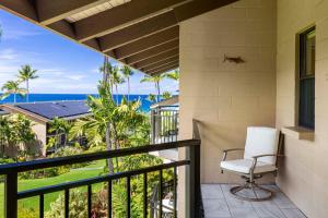 a chair on a balcony with a view of the ocean at Kona Makai 5307 in Kailua-Kona +29 photos