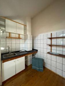 a kitchen with white tiled walls and wooden floors at Vila Zara in Gevgelija