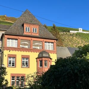 a yellow and orange house with a roof at Haus Till E in Zell an der Mosel