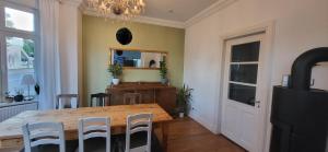 a dining room with a wooden table and chairs at Freienwohnung 80qm, 4 Personen mit Kamin in Pinneberg