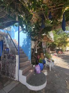 niebieski budynek ze schodami, stołem i krzesłami w obiekcie Rena's Rooms Μελίντα w mieście Melínta