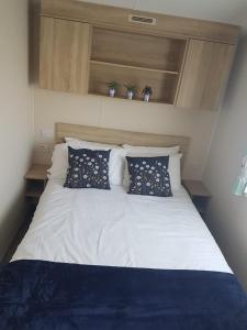 a white bed with pillows on it in a bedroom at Meadow bay Hayling Island-Iona in South Hayling