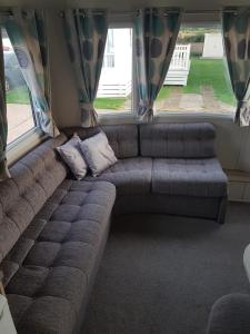 a couch in a living room with a window at Meadow bay Hayling Island-Iona in South Hayling