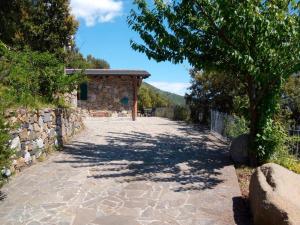 a stone walkway leading to a building with a tree at Altamarea Private Retreat in Corniglia +15 photos