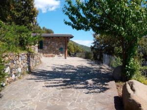 a stone walkway leading to a building with a tree at La Casetta in Corniglia