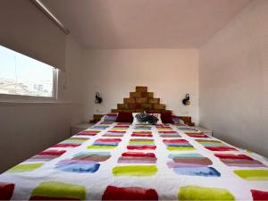 a bedroom with a large bed with a colorful quilt at Chalet en La Mata a 50 metros de la playa in Torrevieja