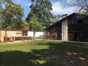 a house with a grass yard next to a building at Casa Estaleiro in Estaleiro