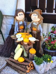deux figurines de personnes avec des citrouilles et des fruits et légumes dans l'établissement Garden Apartments Janša, à Radovljica