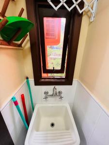 łazienka z umywalką, oknem i szczoteczkami do zębów w obiekcie MRG Bavária 1D Próximo ao centro Gramado w mieście Gramado
