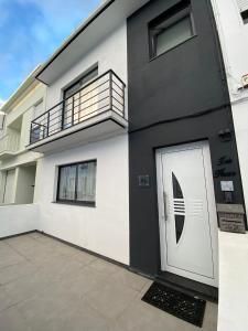 ein schwarzes und weißes Haus mit einer weißen Tür in der Unterkunft Iris House AL Azores in Ponta Delgada