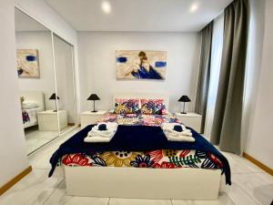 ein Schlafzimmer mit einem Bett mit einer farbenfrohen Tagesdecke in der Unterkunft Iris House AL Azores in Ponta Delgada
