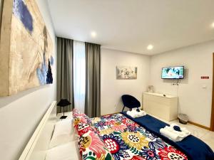 ein Hotelzimmer mit einem Bett und einem TV in der Unterkunft Iris House AL Azores in Ponta Delgada