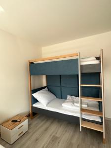 a bunk bed with white pillows and a wooden floor at KK Apartments in Prague