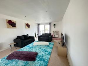 a living room with a couch and a blue rug at Water Front APT Walk to the Beach & City Centre in Swansea