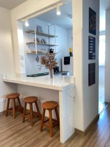 a kitchen with a counter with two stools and a table at Apto centro Umuarama in Umuarama