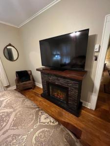 a living room with a fireplace and a flat screen tv at Opus House Historic Natchitoches in Natchitoches