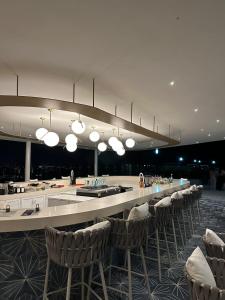 a large room with a bar with chairs and lights at Maritima in Nuevo Vallarta 