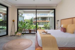 a bedroom with a large bed and a large window at XP Tulum in Tulum
