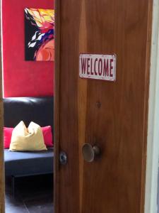 Una señal en una puerta que dice bienvenida en La Casa Colorata, en Pisa