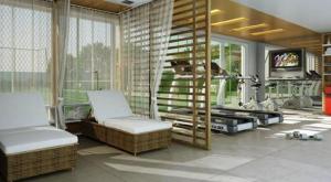 ein Wohnzimmer mit zwei Stühlen und einem Fernseher in der Unterkunft Apartamento Rio Marina Resort in Mangaratiba