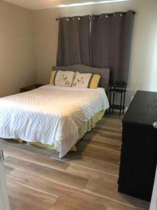 a bedroom with a bed and a wooden floor at Hinton Alberta Vacation Home in Hinton