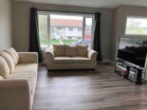 a living room with a couch and a television at Hinton Alberta Vacation Home in Hinton