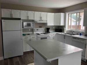 a kitchen with white appliances and white cabinets at Hinton Alberta Vacation Home in Hinton