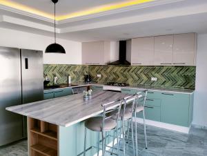 una cocina con armarios azules y una barra con taburetes en Villa Agate, en Midoun