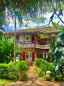 un gran edificio rojo y blanco con árboles y arbustos en Finca El Descanso del Duque, en La Palmilla